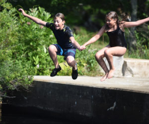 Logan Murff, 13, and Kellan Murff, 10, jump off the platform at the Bristol Mills Dam on Wednesday, July 11. (Jessica Picard photo)