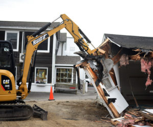 Damariscotta Road Commissioner Hugh Priebe starts demolishing the barbershop in the municipal parking lot early Wednesday, July 11. The demolition will make way for new public restrooms. (Jessica Picard photo)
