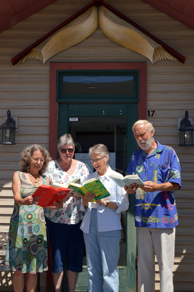 From left: Skidompha Secondhand Book Shop co-manager Rosie Bensen, Skidompha Library Executive Director Pam Gormley, longtime shop volunteer Janice Lindsay, and shop co-manager Rem Briggs pose with half-off novels during the shop's 50th anniversary celebration Saturday, July 21. (Johanna Neeson photo)