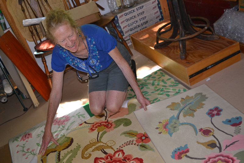 Walpole artist Susan Connery with her floorcloth designs in her studio. (Christine LaPado-Breglia photo)