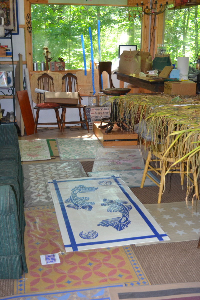 An array of Susan Connery Designs floorcloths share space with drying garlic in Susan Connery's Walpole studio. (Christine LaPado-Breglia photo)