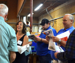 Lincoln County Publishing Co. graphic designer Megan Hyson hands out copies of a special section printed during the business's open house Wednesday, June 27. (Amber Clark photo)