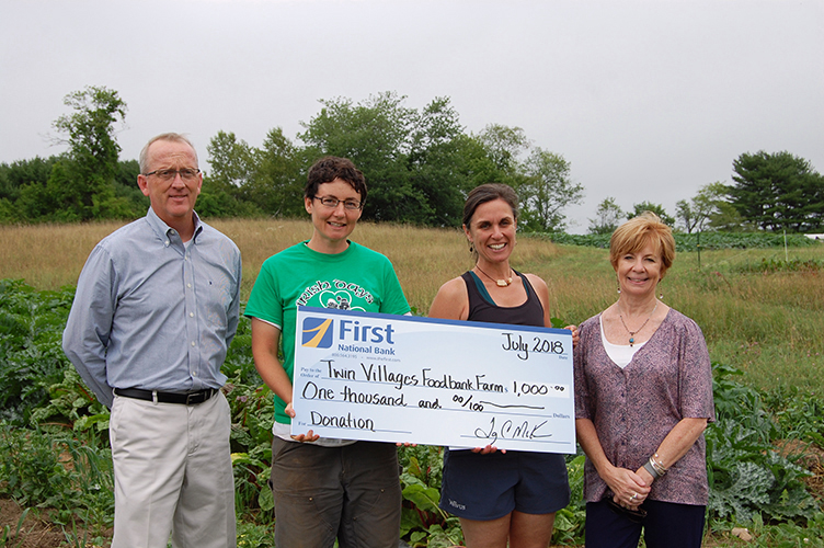 Gathered at the farm for a check presentation are (from left) Tony McKim, president and CEO of First National Bank; Sara Cawthon, farm manager at Twin Villages Foodbank Farm; Megan Taft, farm development at Twin Villages Foodbank Farm; and Susan Norton, eecutive vice president and chief administrative officer at First National Bank.