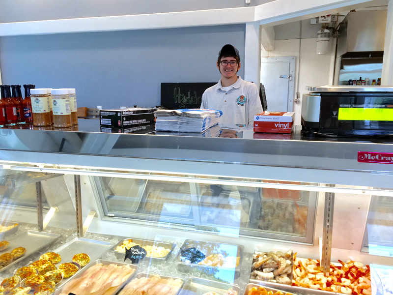 Dylan Peters works the seafood counter at Pinkham's. (Suzi Thayer photo)