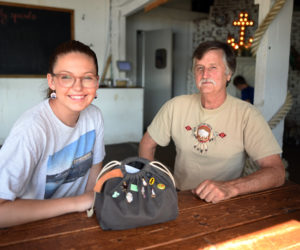 McKinley Neuser sits at The Contented Sole with Carl Reilly Sr., who found and returned her purse after it fell off of her scooter Monday, July 30. (Jessica Picard photo)