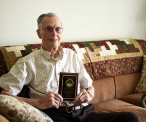 Harry Emmons, 101, holds a plaque recognizing him as Damariscotta's eldest resident in his apartment at Schooner Cove on Monday, July 30. (Jessica Picard photo)