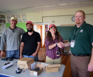 The Lincoln County Emergency Management Agency brings new radios to the Monhegan Volunteer Fire Department on Monday, Aug. 20. From left: Monhegan Fire Chief Gregory Rollins, Assistant Fire Chief Mott Feibusch, Emergency Management Deputy Director Jessica Stevens, and Lincoln County EMA Director Casey Stevens. (Jessica Picard photo)