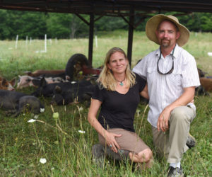 Holly and John Arbuckle with their pigs on Singing Prairie Farm in Newcastle, Wednesday, Aug. 8. (Jessica Picard photo)