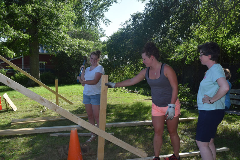 From left: Hannah Leitzell, Clara Brown, and Michelle Brand work on the new outdoor classroom at Wiscasset Elementary School. (Jessica Clifford photo)