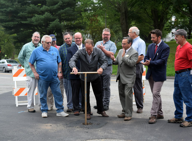 Wiscasset Water District Board of Trustees Chair Gregg Wood turns a valve to commemorate the completion of an 11-year project to replace about 35,000 feet of pipe more than a century old. (Jessica Clifford photo)