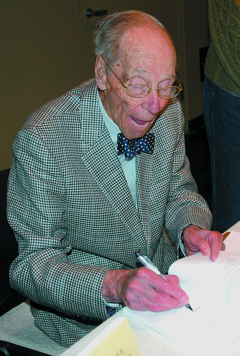 Ted Clapp signs a copy of his first book at Skidompha Library, Damariscotta, in 2013. The former Lincoln County News columnist passed away Aug. 19 at the age of 99.