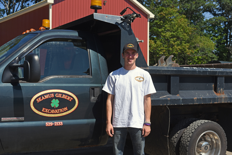 Seamus Gilbert, 18, stands next his dump truck at his office in Nobleboro, Tuesday, Sept. 4. (Jessica Picard photo)