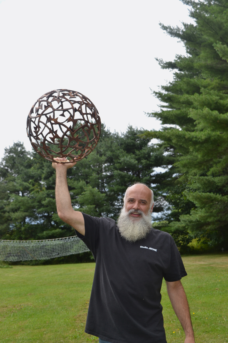 Metal artist Jay Sawyer poses with "Constellation I" on the grounds of Studio JBone in Warren. (Christine LaPado-Breglia photo)