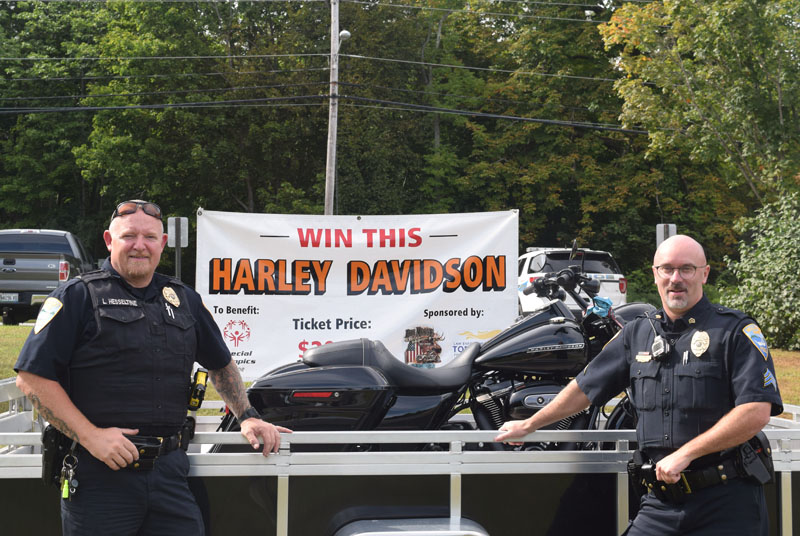 Wiscasset Police Chief Larry Hesseltine (left) and Sgt. Craig Worster stand in front of a Harley-Davidson motorcycle, the prize in an ongoing raffle to benefit Special Olympics Maine. The Wiscasset Police Department is selling raffle tickets during office hours, an example of how Hesseltine wants the department to be more active in the community. (Jessica Clifford photo)