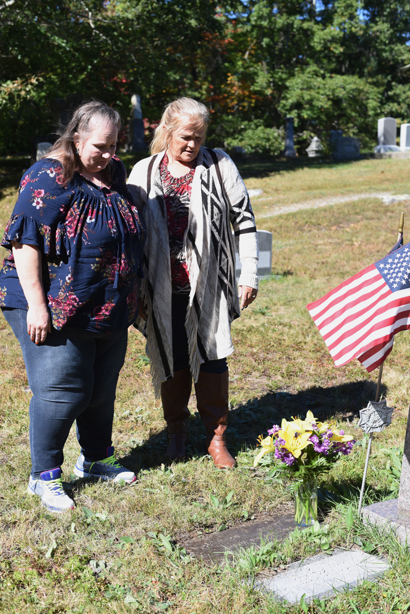 Sisters Carolyn Mattern (left) and Liz Michaud visit the grave of their late brother, Sheldon "Skip" Cushing, in the Chamberlain Cemetery in Round Pond on Oct. 5. (Jessica Picard photo)