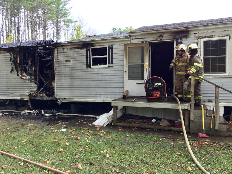 Bristol 1st Assistant Fire Chief Jared Pendleton (left) and Damariscotta Deputy Fire Chief Jim Hall confer on the steps of a mobile home at 15 South Road in Damariscotta on Sunday, Oct. 21. A furnace malfunction caused a fire that destroyed the home, according to Hall and the homeowner, John Sprague. (Suzi Thayer photo)