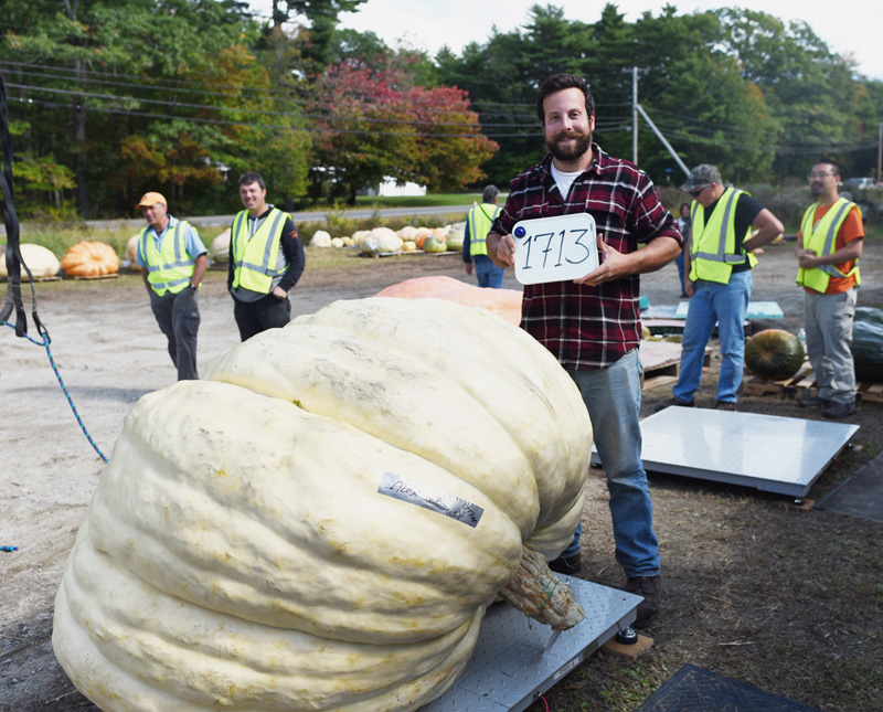 Alex Noel, of Connecticut, poses with his first-place 1,713-pound giant pumpkin during the Damariscotta Pumpkinfest weigh-off at Pinkham's Plantation in Damariscotta, Sunday, Sept. 30. (Jessica Picard photo)