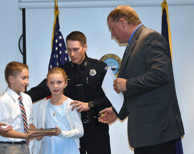 Waldoboro Selectman Abden Simmons (right) prepares to swear in John Lash as Waldoboro's police chief as Lash's children assist. (Alexander Violo photo)