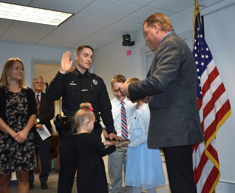 Waldoboro Selectman Abden Simmons (right) administers the oath of office to Police Chief John Lash as Lash's children hold the Bible and his wife looks on. (Alexander Violo photo)