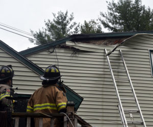 Firefighters examine damage to the siding of a home on Cooper Road in Whitefield after extinguishing an electrical fire the afternoon of Monday, Oct. 1. There were no injuries as a result of the fire. (Jessica Clifford photo)