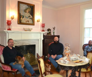 The new owners of the former Musical Wonder House in Wiscasset relax in the music room with their dogs. From left: Dana Long, Michael Collins, and Dan Dyer. (Charlotte Boynton photo)