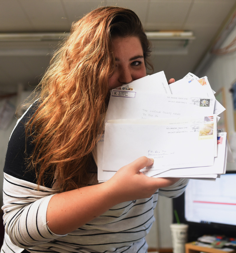 Maia Zewert, the marketing and engagement coordinator for The Lincoln County News, holds a pile of responses to the reader survey. More than 500 readers have submitted their thoughts and opinions so far. (Jessica Picard photo)