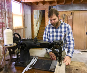 Mike Bartles works at a 19th-century Singer 7 Class sewing machine in his new sail loft in Boothbay. (Suzi Thayer photo)