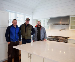 From left: contractor Paul Leeman III, developer Xavier Cervera, and architect Tor Glendinning stand in the kitchen of Cervera's new house in Round Pond, Monday, Nov. 26. (Jessica Picard photo)