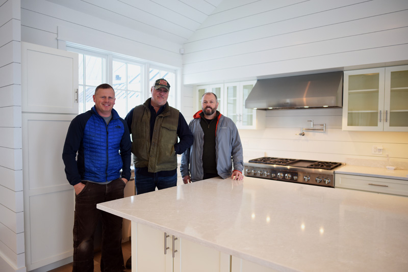 From left: contractor Paul Leeman III, developer Xavier Cervera, and architect Tor Glendinning stand in the kitchen of Cervera's new house in Round Pond, Monday, Nov. 26. (Jessica Picard photo)