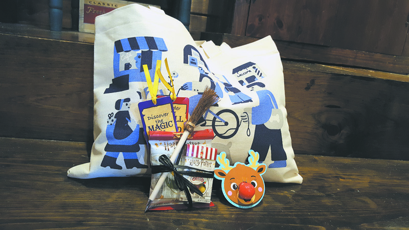 Small Business Saturday gifts with purchase at Smitten Collectibles & Nerdy Treasures include a sour Rudolph ring pop, a Harry Potter Honeyduke's gift set, and a tote bag. (Amber Clark photo)