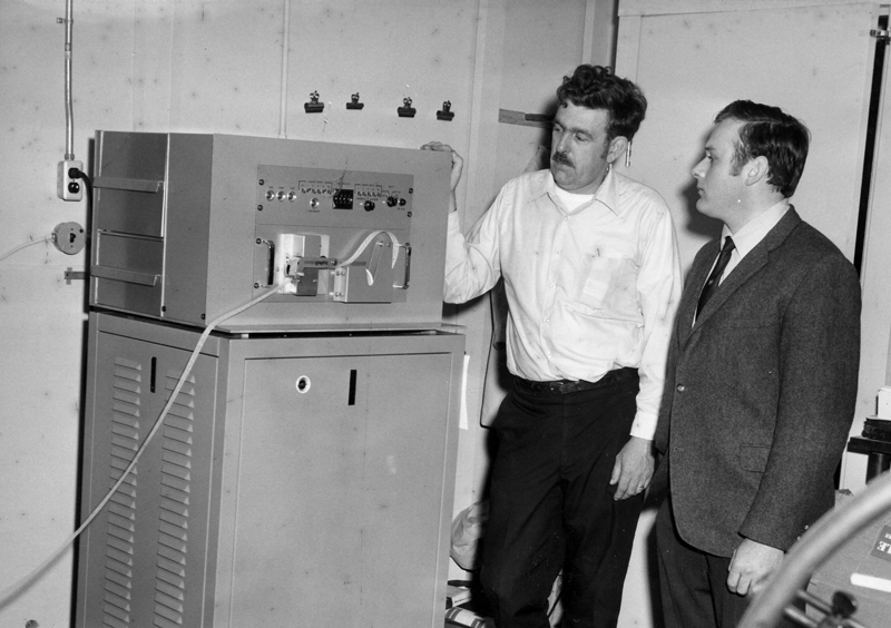 Sam Roberts (left) examines a Compugraphic typesetting terminal after its installation at The Lincoln County News circa 1969. The system was the first of its kind in the state.