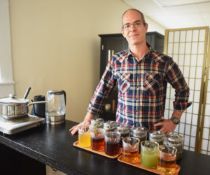Joshua Jacobs, president of Samovar Tea, stands with a sampling of teas in the business's new tasting room in downtown Newcastle, Friday, Nov. 9. (Jessica Picard photo)
