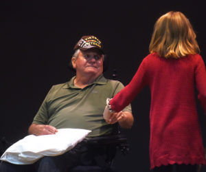 Veteran Paul Kelsey Sr. holds the hand of his granddaughter, fourth-grader Grace Bryant, after she read his biography during a Veterans Day ceremony at South Bristol School on Tuesday, Nov. 13. (Jessica Picard photo)