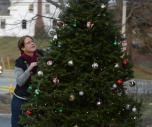 Mary Kate Reny puts the finishing touches on the tree by the Second Congregational Church in Newcastle during the 2017 Villages of Light event. (Paula Roberts photo, LCN file)