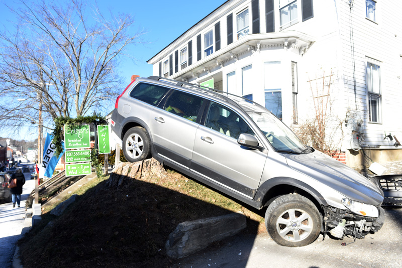 A station wagon at rest on a stump in the front yard of Crissy's Breakfast & Coffee Bar in Damariscotta on Thursday, Dec. 13. The car struck the building while backing up. (Jessica Picard photo)