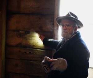 Phil Averill uses a flashlight to illuminate a wall of the old Pemaquid Mill during a tour Thursday, Jan. 17. The boards for the wall were cut with an up-and-down saw, he said. (Jessica Picard photo)