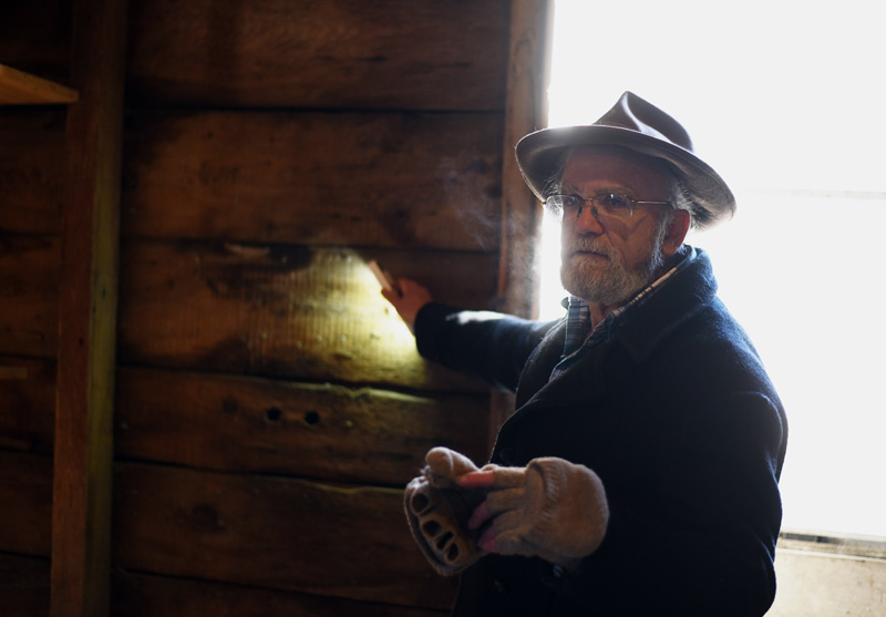 Phil Averill uses a flashlight to illuminate a wall of the old Pemaquid Mill during a tour Thursday, Jan. 17. The boards for the wall were cut with an up-and-down saw, he said. (Jessica Picard photo)