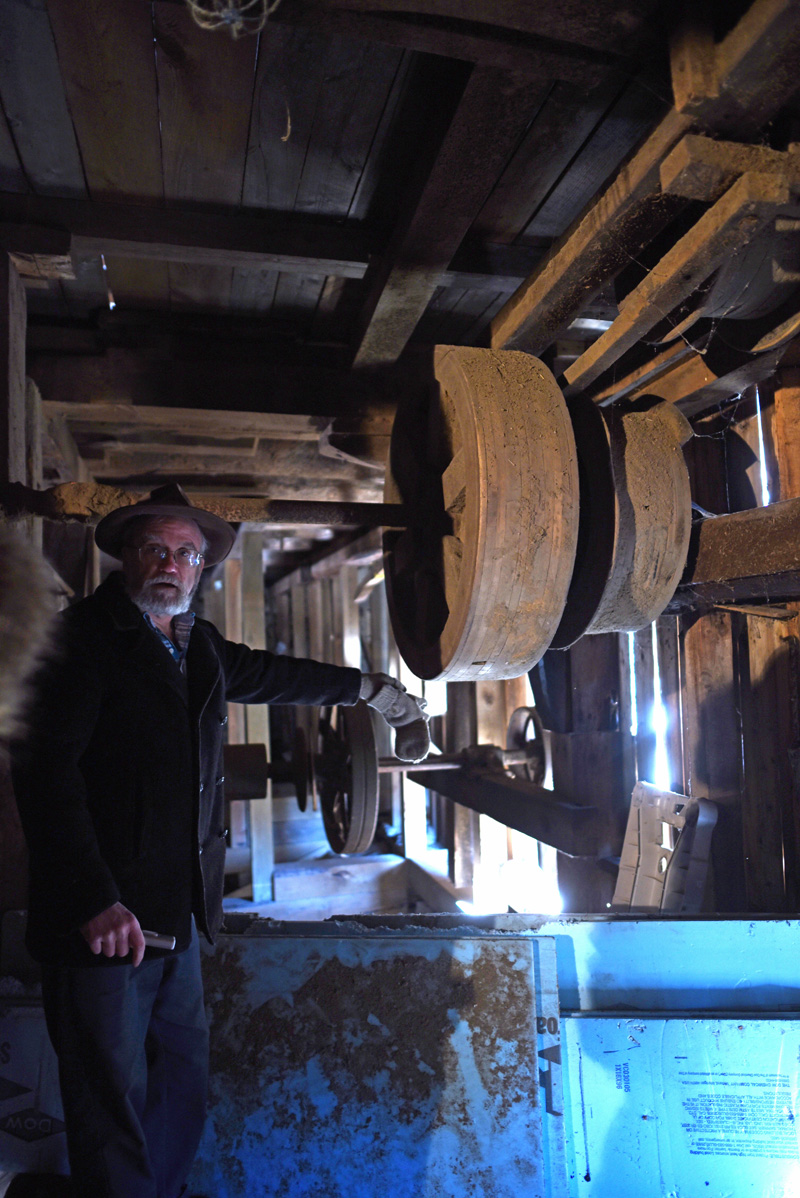 Phil Averill points out equipment in the basement of the mill. (Jessica Picard photo)