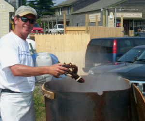 Charlie Herrick drops a lobster into a pot outside his Schooner Landing Restaurant and Marina in 2000. The Schooner Landing co-owner died Jan. 2 at the age of 66. (LCN file photo)