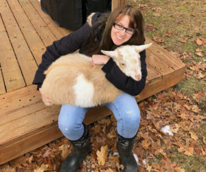 Megan McLaughlin sits on her back deck in Woolwich with one of her four goats, Campbell. McLaughlin will start work as the new county planner in February. (Photo courtesy Megan McLaughlin)