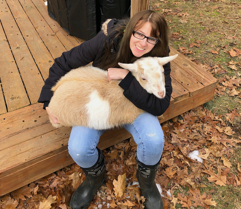 Megan McLaughlin sits on her back deck in Woolwich with one of her four goats, Campbell. McLaughlin will start work as the new county planner in February. (Photo courtesy Megan McLaughlin)