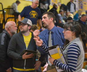 Medomak Valley girls basketball coach Ryan McNelly (center) confers with his brother, Lucas McNelly, at halftime of a home game against Gardiner on Dec. 28. (Paula Roberts photo)