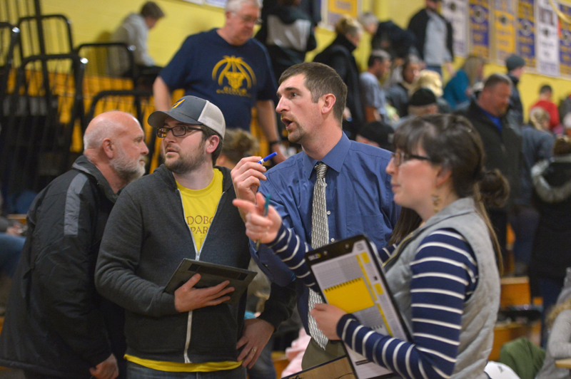 Medomak Valley girls basketball coach Ryan McNelly (center) confers with his brother, Lucas McNelly, at halftime of a home game against Gardiner on Dec. 28. (Paula Roberts photo)