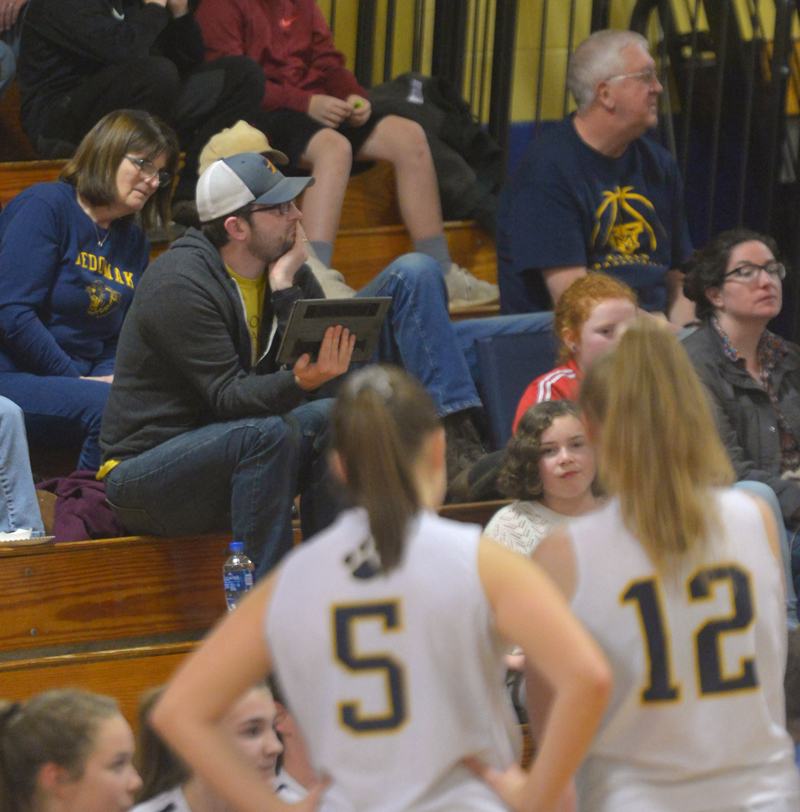 Lucas McNelly holds his tablet while he watches a Medomak Valley High School girls basketball home game. Lucas McNelly, brother of MVHS girls basketball coach Ryan McNelly, keeps statistics for the team. (Paula Roberts photo)