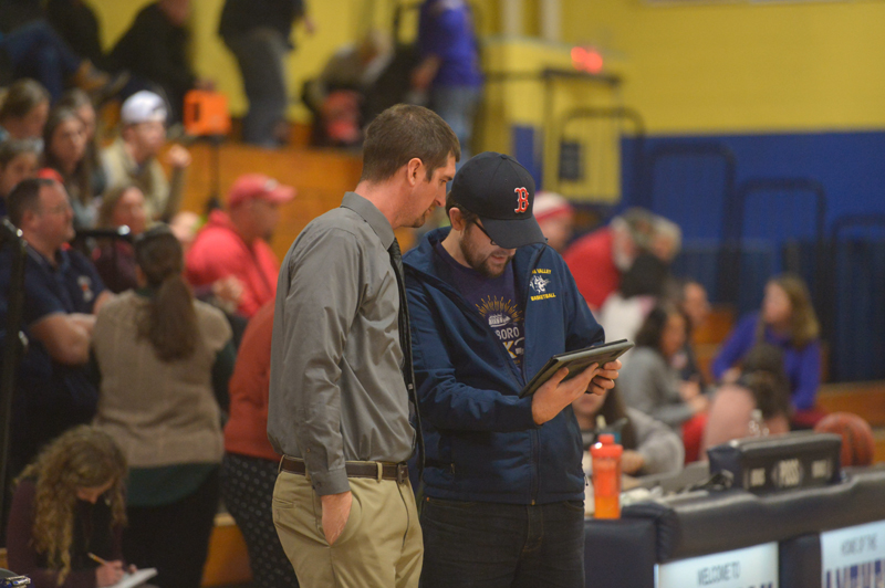 Medomak Valley High School girls varsity basketball coach Ryan McNelly and his brother, Lucas McNelly, review statistics from a recent home game. (Paula Roberts photo)