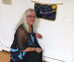 Cathie Stebbins Peterson and her Starry Night wall hanging inspired by Vincent van Gogh's iconic painting The Starry Night. It is unframed and hangs from a beaver stick, as Peterson calls it.