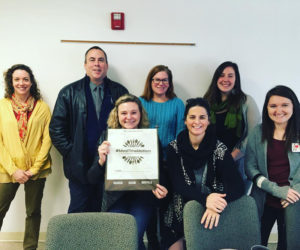 Community members at the December Substance Use Prevention Partnership meeting pose with a reusable bag they designed for a substance-use prevention campaign.