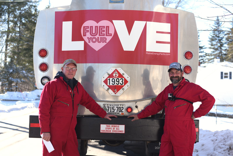 Ralph Eugley (left) and Nick Tilas, of Colby & Gale Inc., show off their decorated truck and special red uniforms for the Fuel Your Love event Thursday, Feb. 14. (Jessica Picard photo)