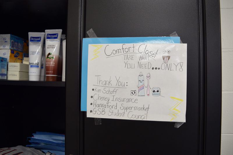 A sign on the door of the comfort closet invites students to take what they need and lists sponsors and supporters of the project. (Jessica Clifford photo)