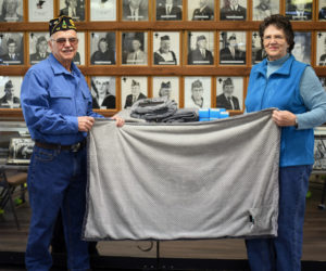 Mike and Shirley Johnson hold up an electric shoulder throw at The American Legion Wells-Hussey Post No. 42 in Damariscotta. The post donated several of the heated throws to the Togus Springs Hospice Unit in Augusta. (Jessica Picard photo)